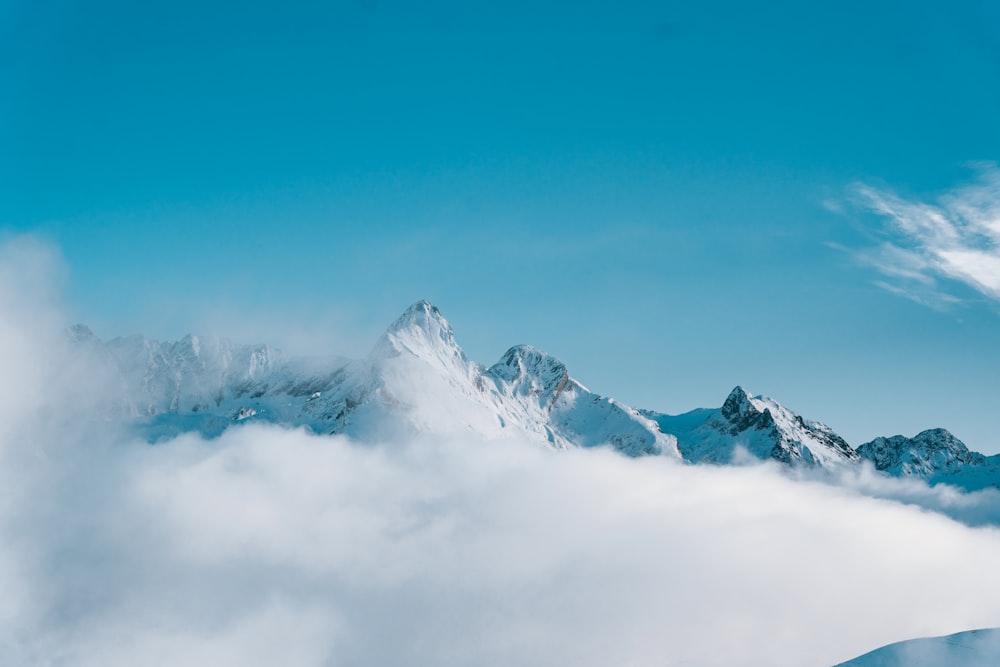 a mountain covered in clouds under a blue sky