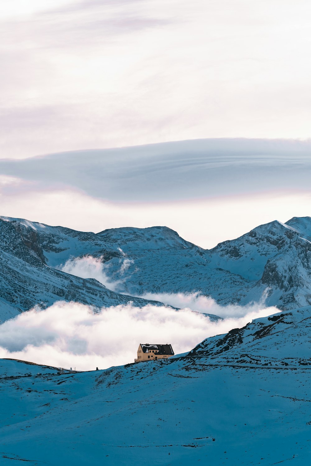 a house in the middle of a snowy mountain range