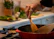 A happy home cook stirring a pot with fresh herbs and spices spread out nearby.
