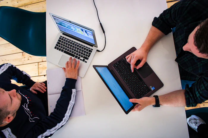 Two specialists working on laptops