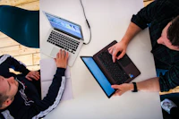 People reviewing digital work on laptops in an office