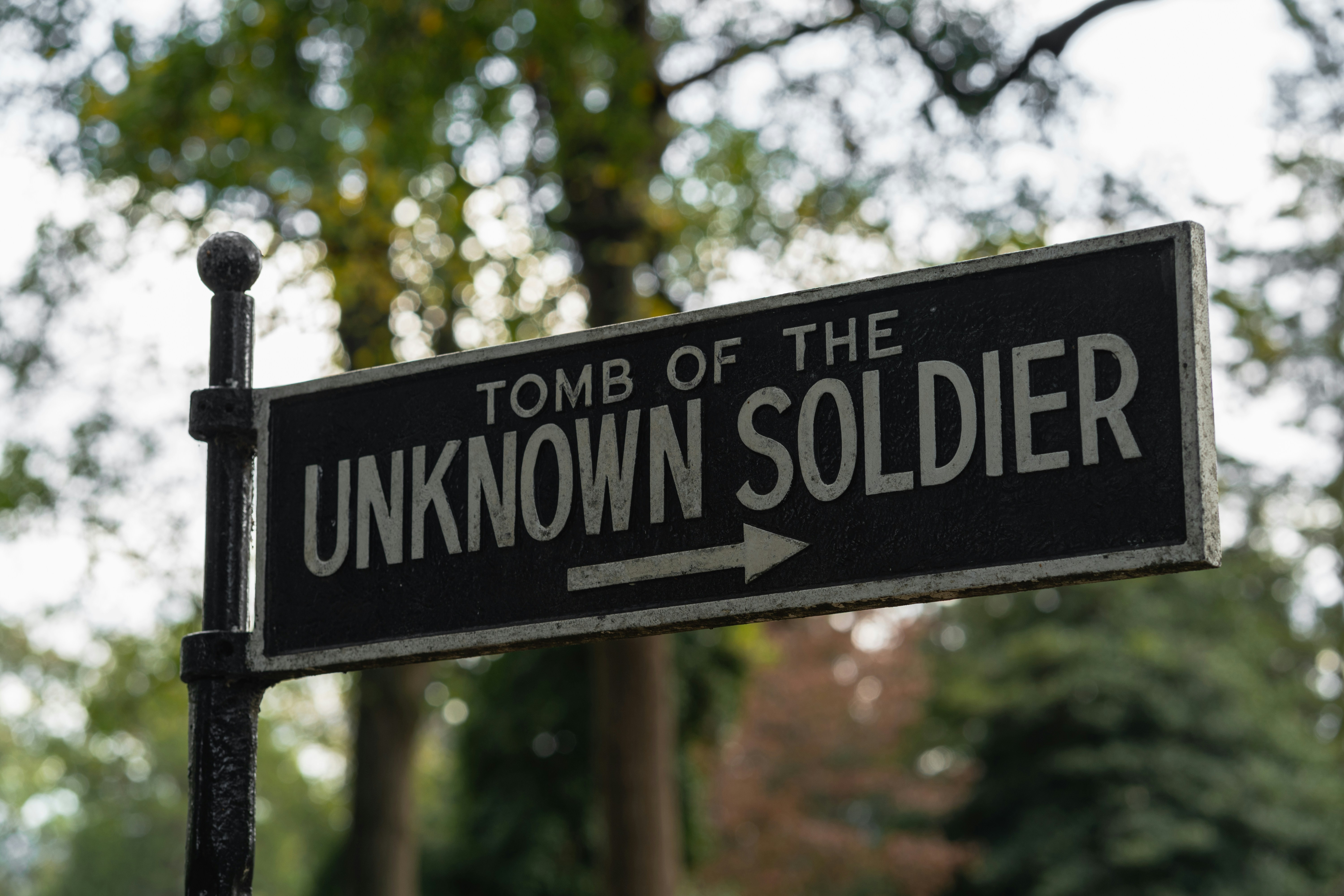a black and white street sign that says unknown soldier, 