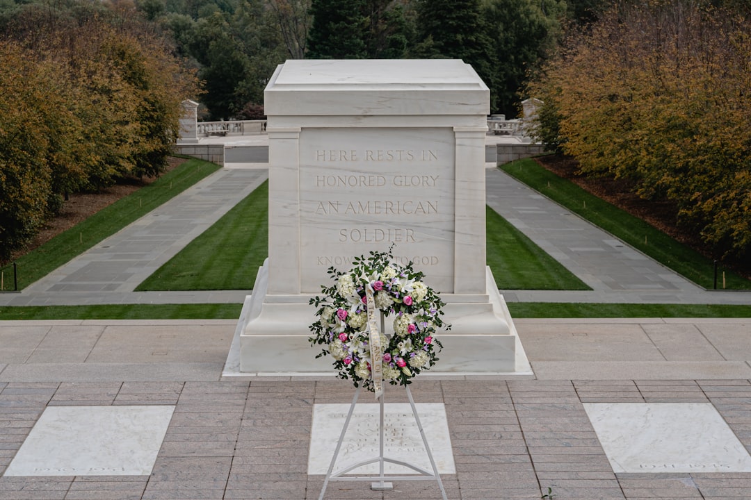 a memorial with a wreath and flowers in front of it,