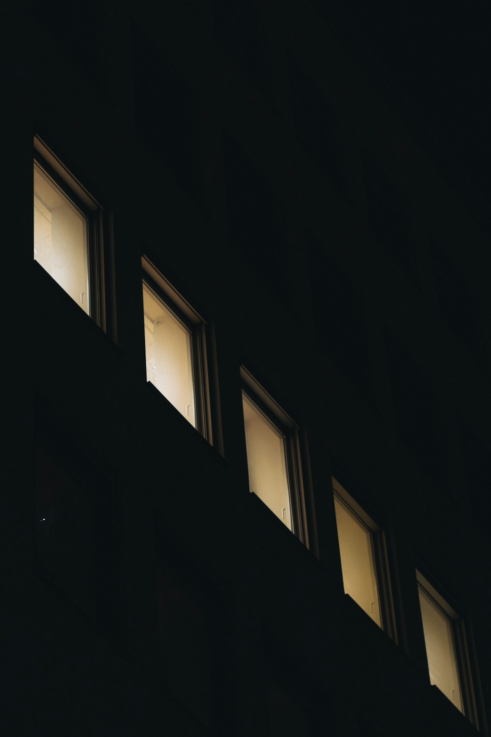 three windows are lit up in the dark