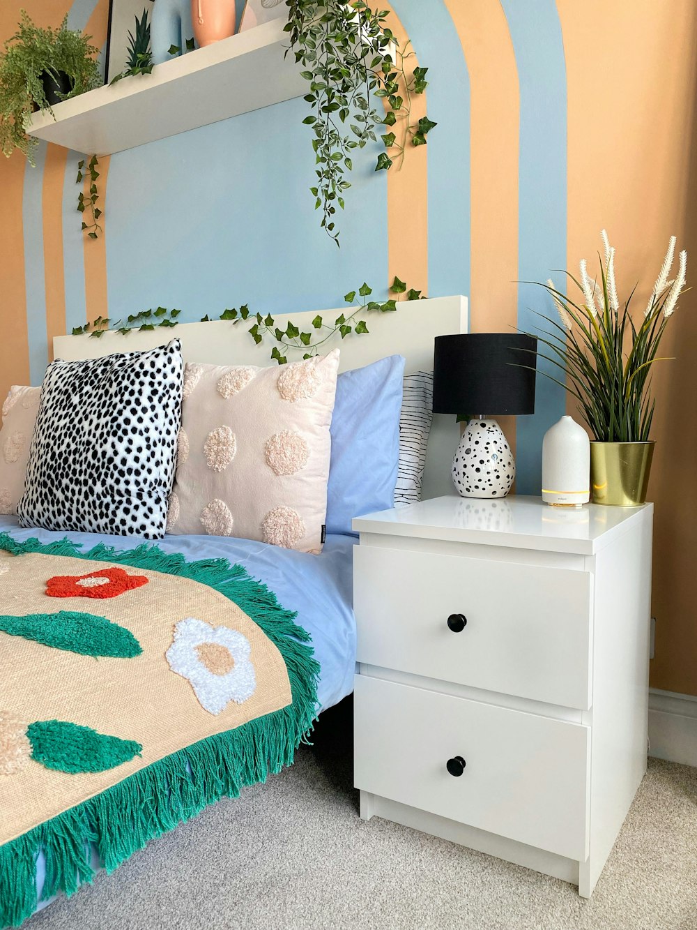 a bedroom with a bed, nightstand, and plants