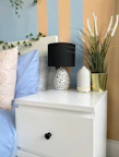 Close-up of a neatly arranged bedside table with fresh flowers and reading lamp.