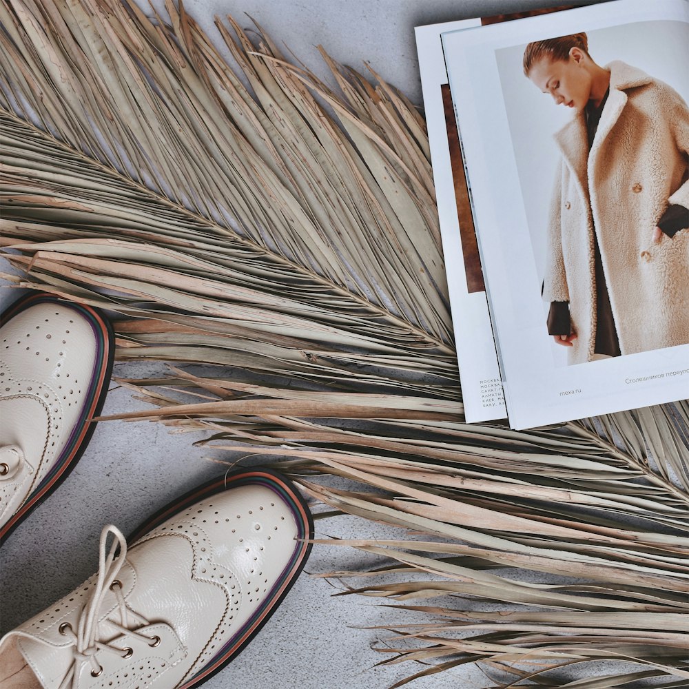 a pair of white shoes next to a magazine