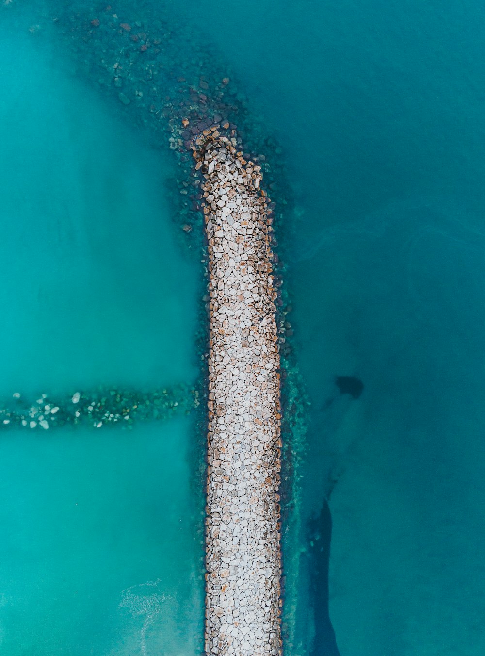 an aerial view of a pier in the water