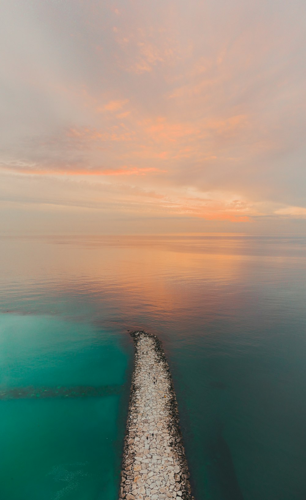 an aerial view of a long pier in the middle of the ocean