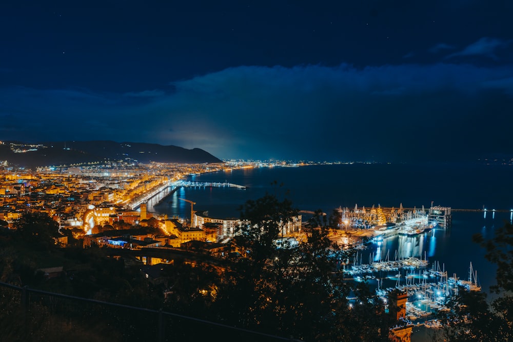 Una vista de una ciudad por la noche desde una colina