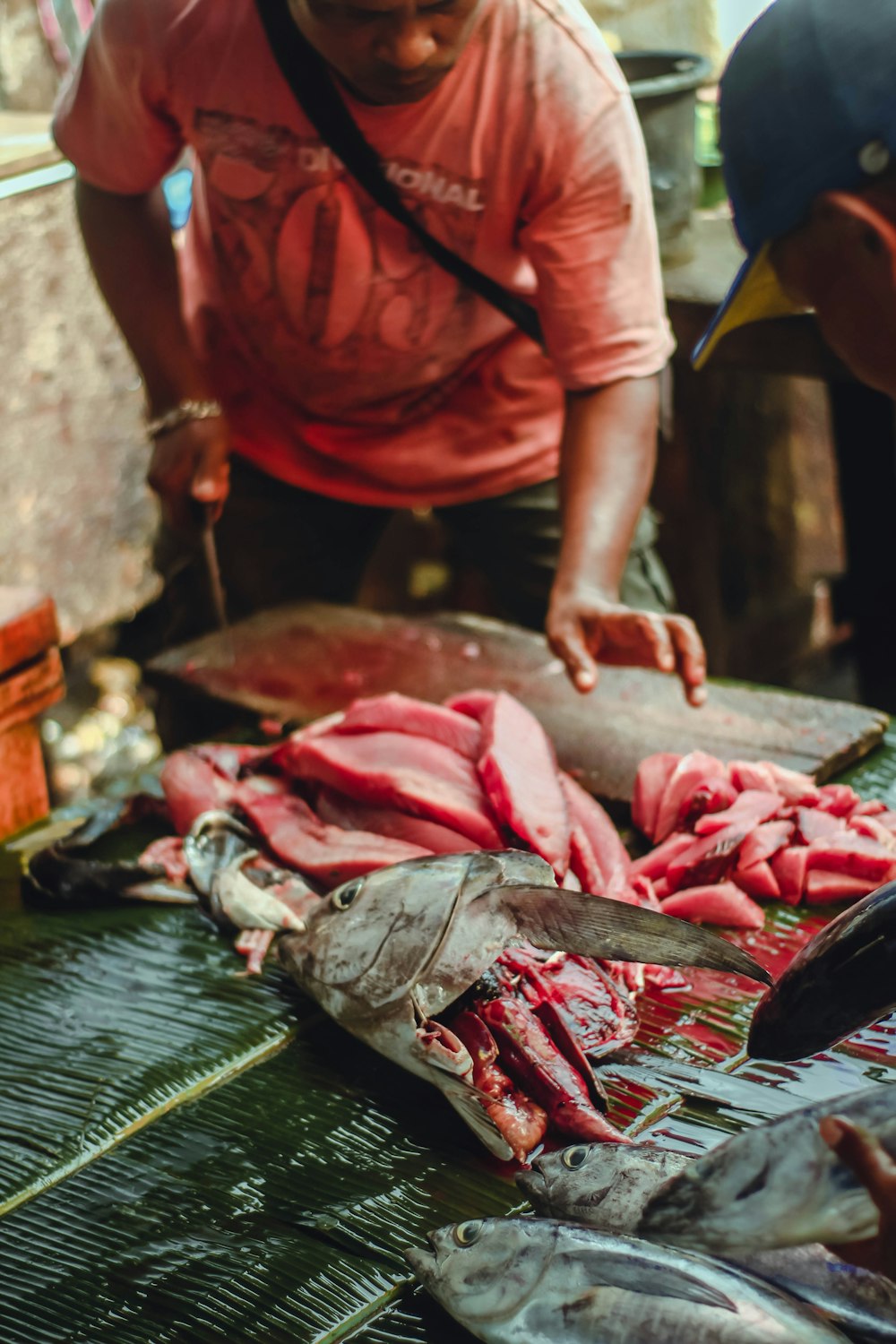 a man standing over a pile of raw fish