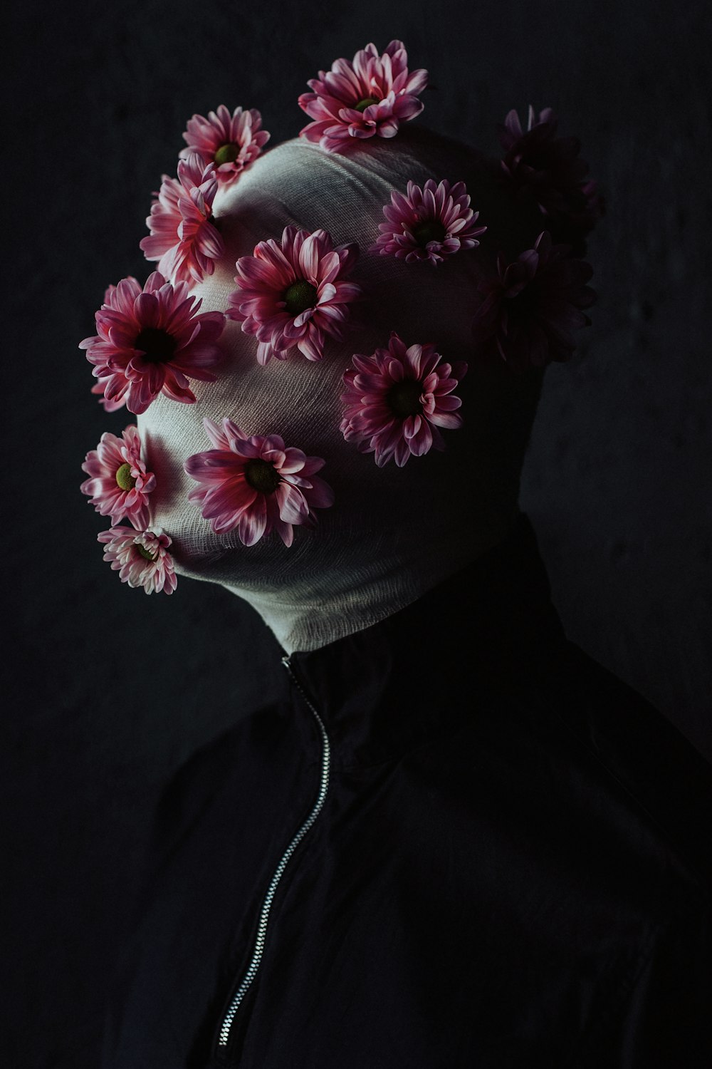 a person with flowers on their head in the dark