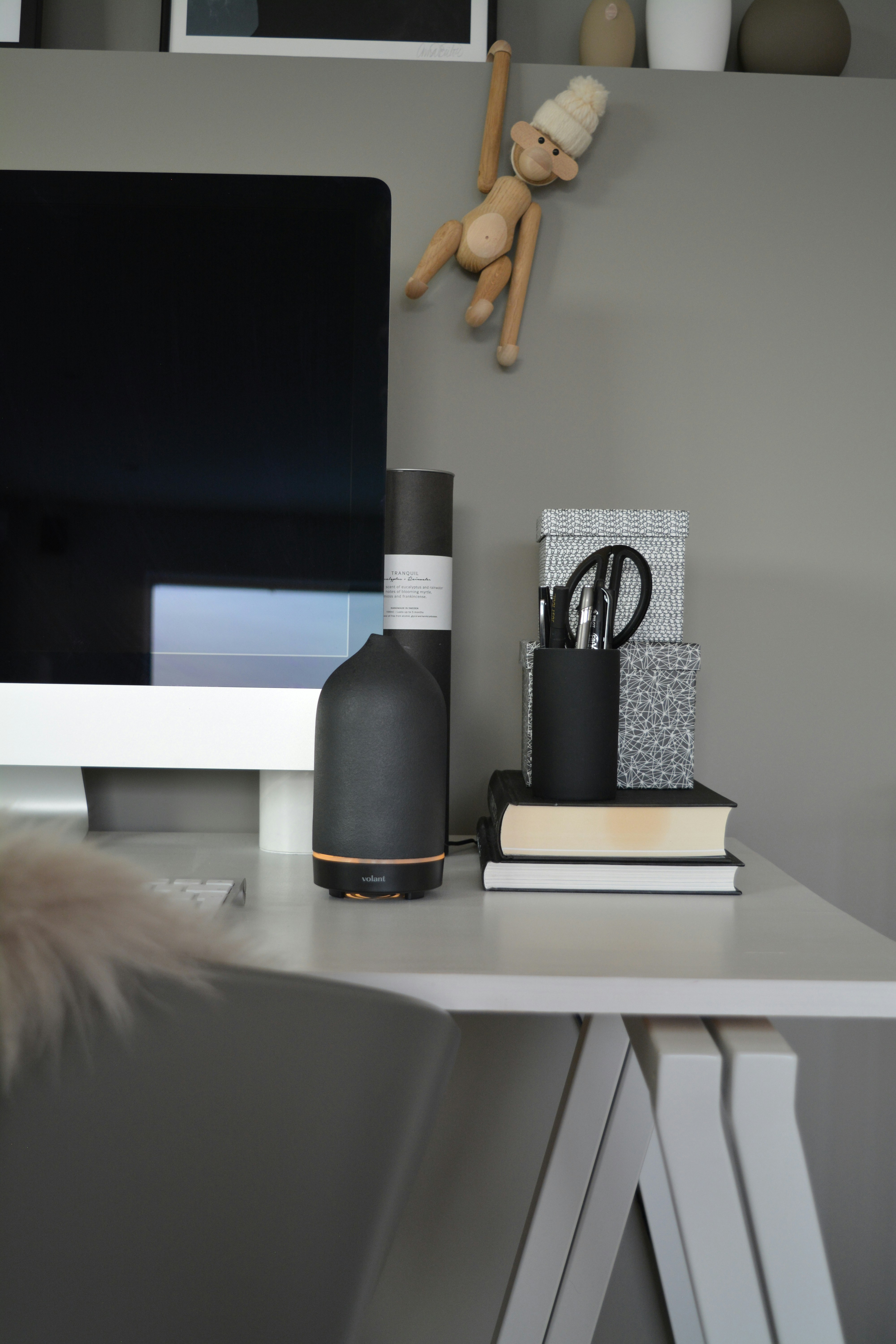 a computer desk with a bottle of wine and a stuffed animal