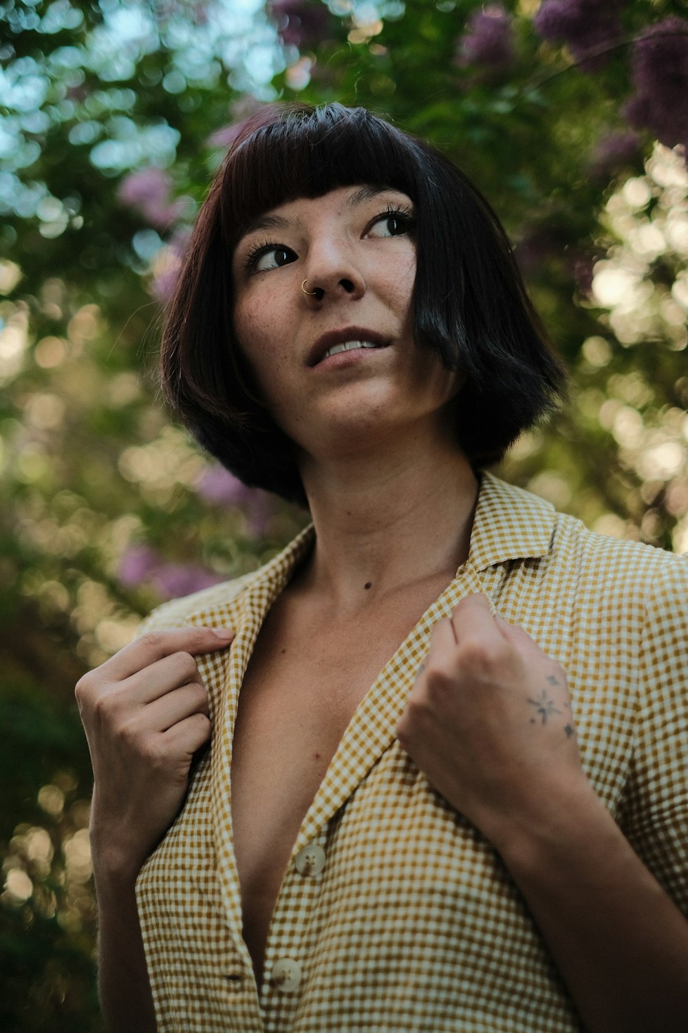 a woman in a checkered shirt poses for a picture