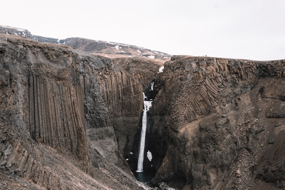 a waterfall in the middle of a canyon