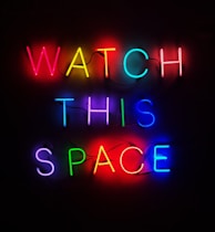 a neon sign that says watch this space