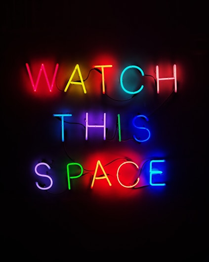 a neon sign that says watch this space