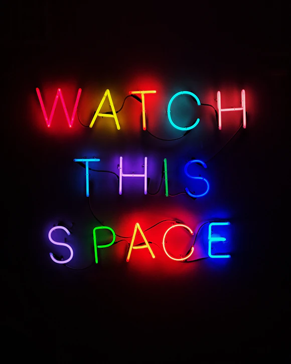 a neon sign that says watch this space