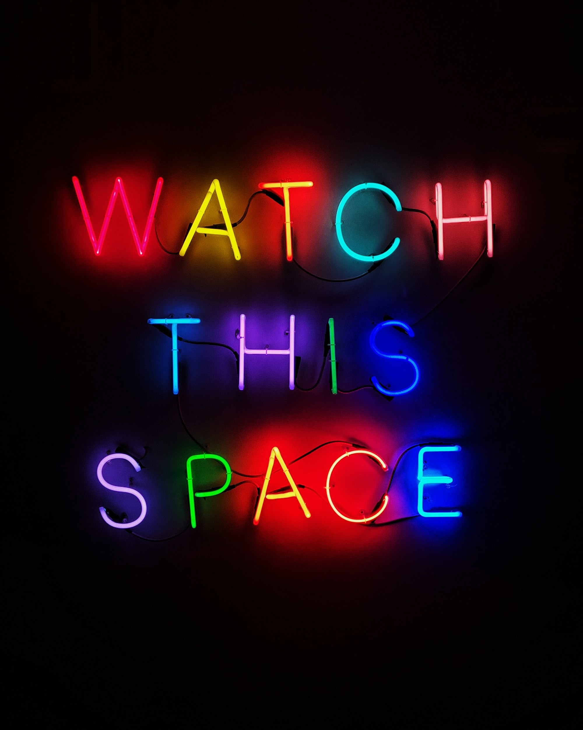 Multi-colored Neon lights which spell out 'Watch This Space'