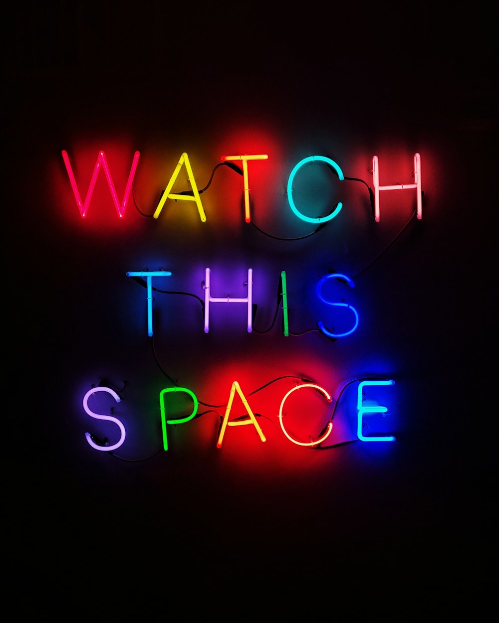 a neon sign that says watch this space