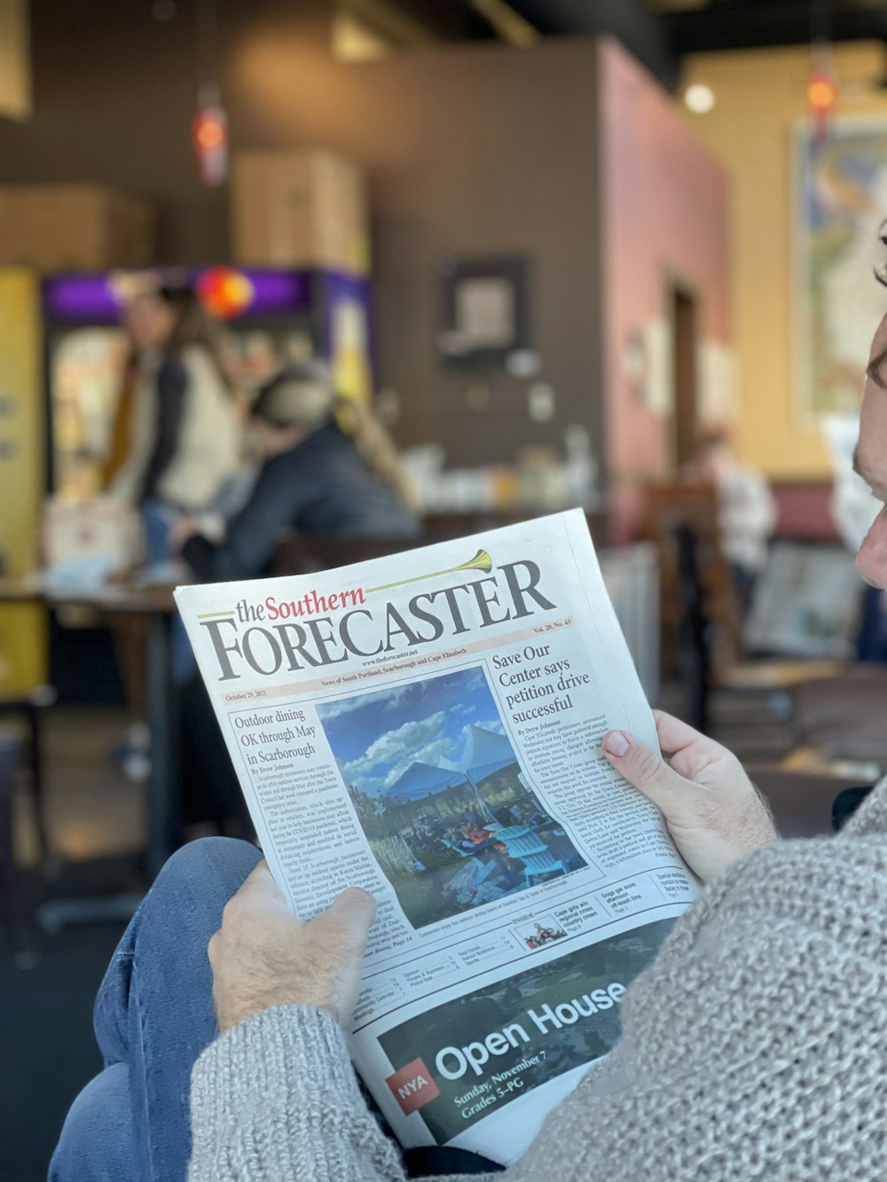 a woman reading a newspaper in a restaurant