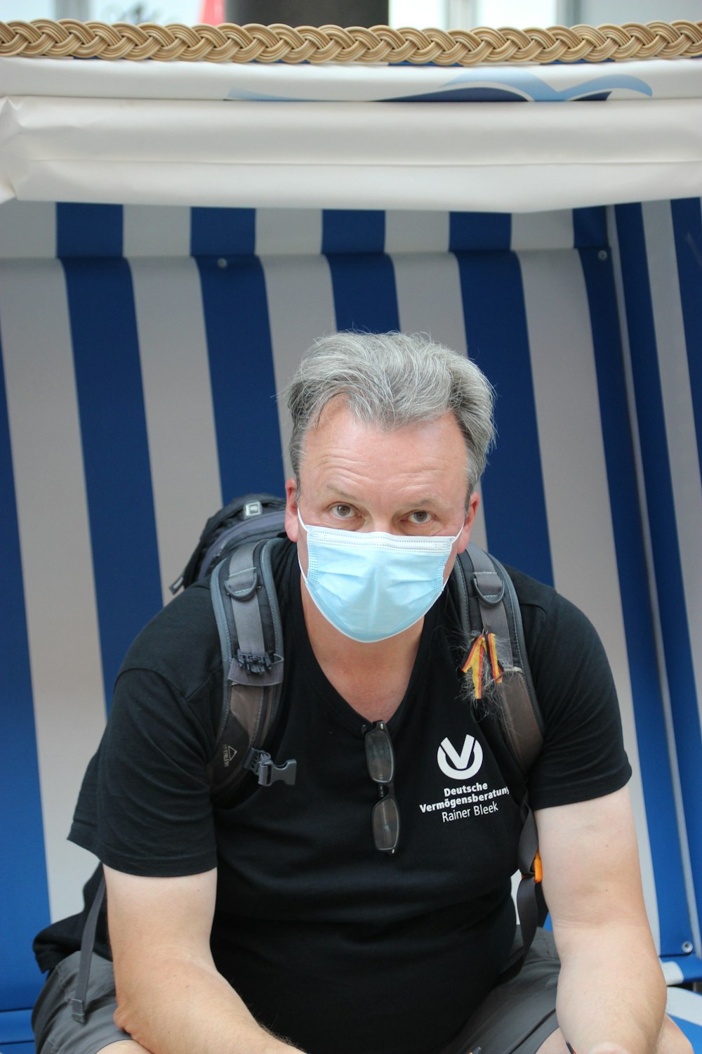 a man wearing a face mask sitting in a chair