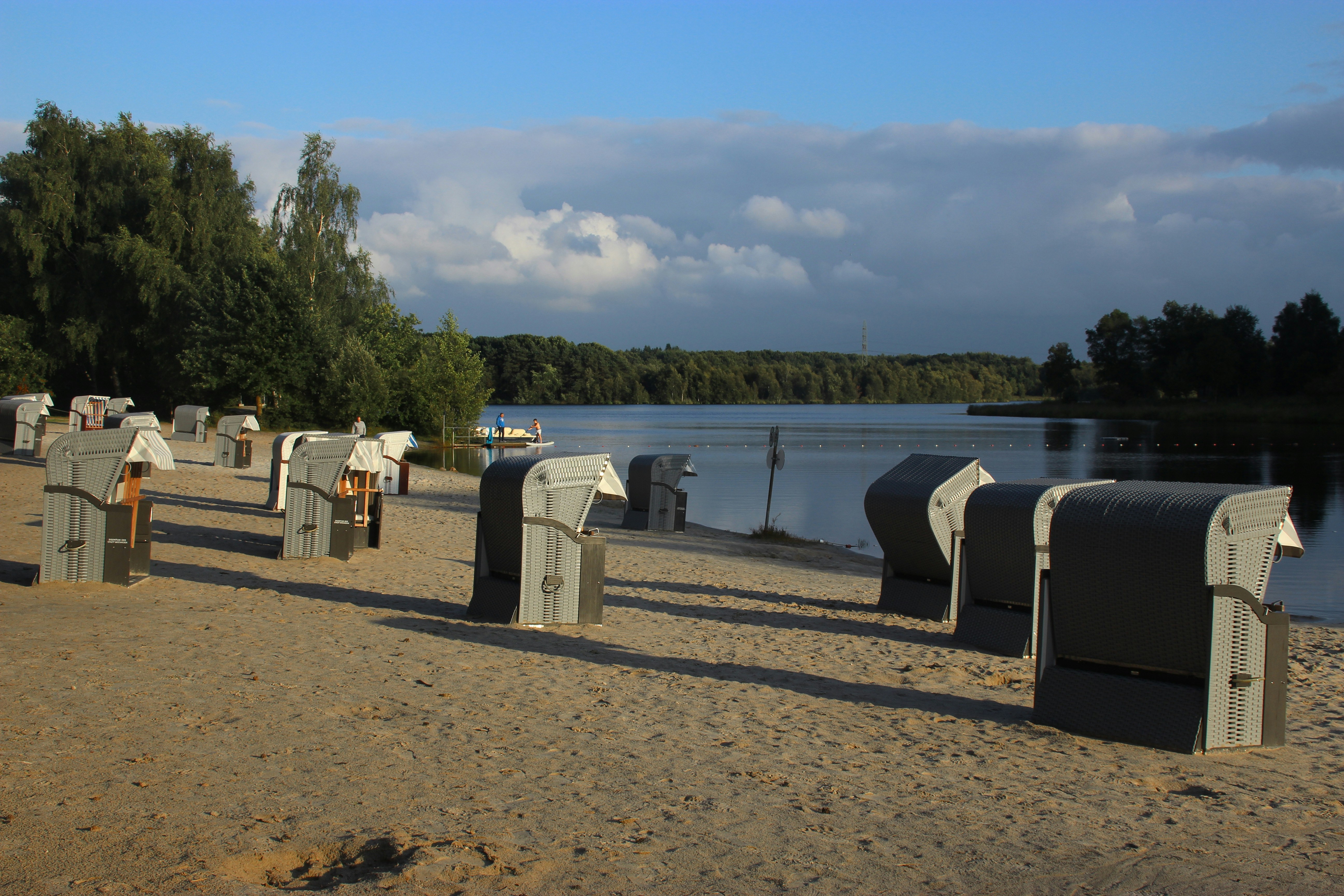 a row of mail boxes sitting on top of a sandy beach