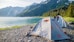 a tent pitched up on the shore of a lake