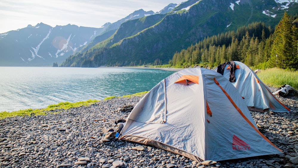 a tent pitched up on the shore of a lake