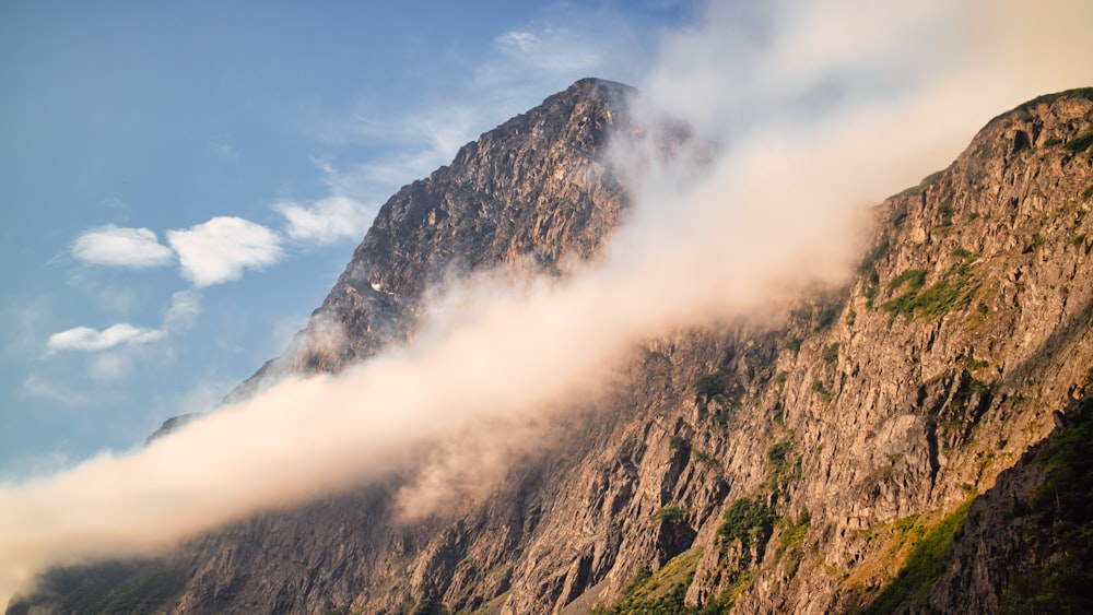 Un grupo de nubes en el cielo con una montaña al fondo