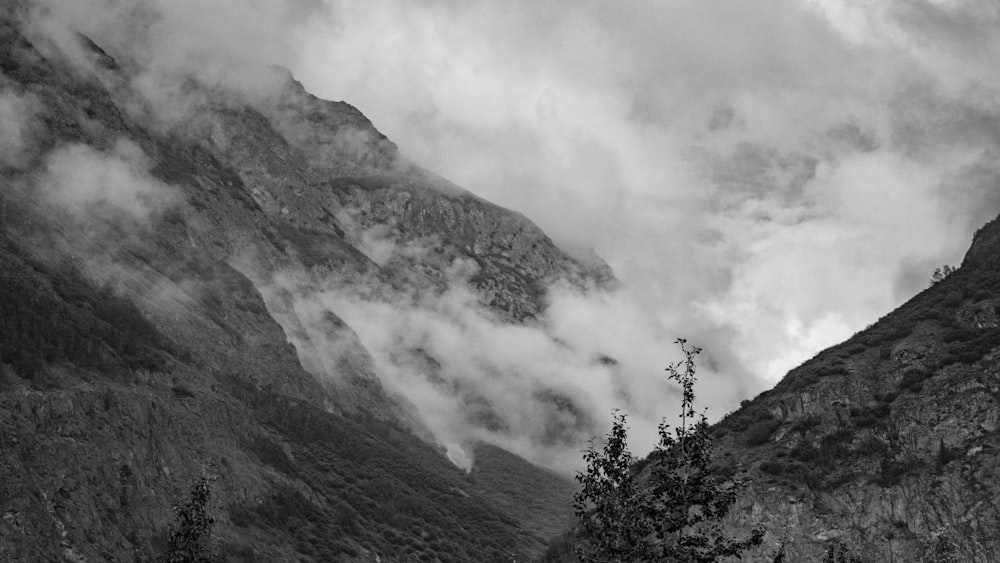 a black and white photo of mountains and clouds