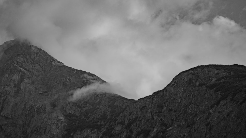 a black and white photo of mountains and clouds