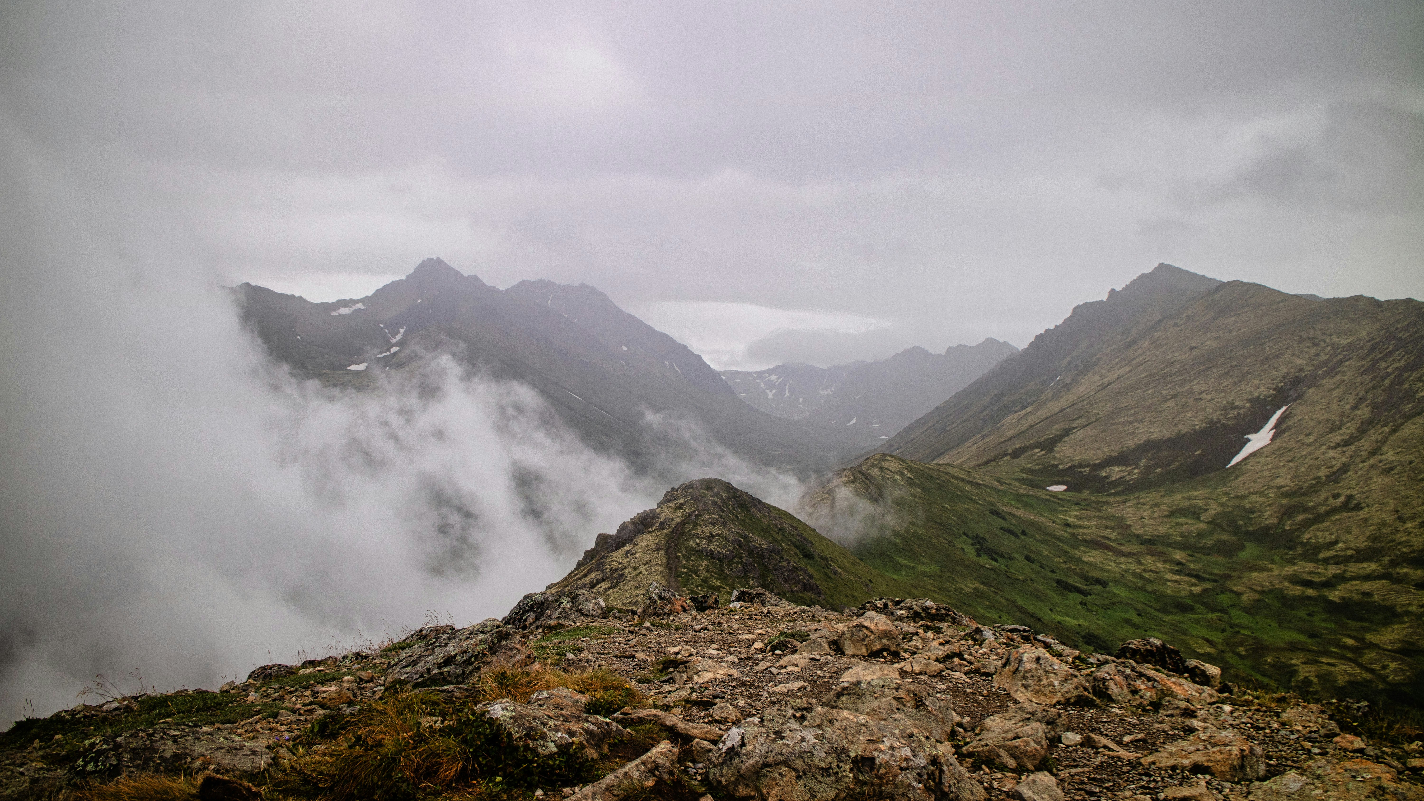 A view of a mountain range with low lying clouds photo – Free Alaska ...