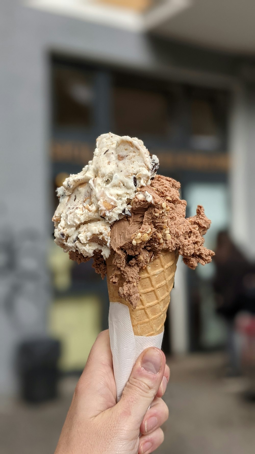 a hand holding a cone of ice cream