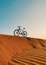 a bike is sitting on top of a sand dune