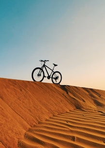 a bike is sitting on top of a sand dune
