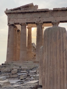 a large stone pillar sitting next to a tall building