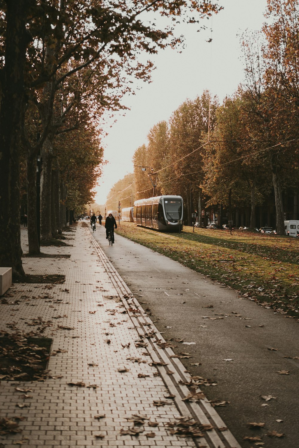 people walking down a sidewalk next to a bus