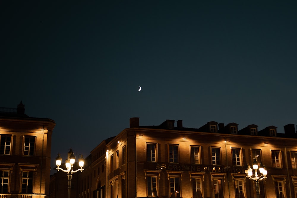 a full moon is seen in the sky over a building