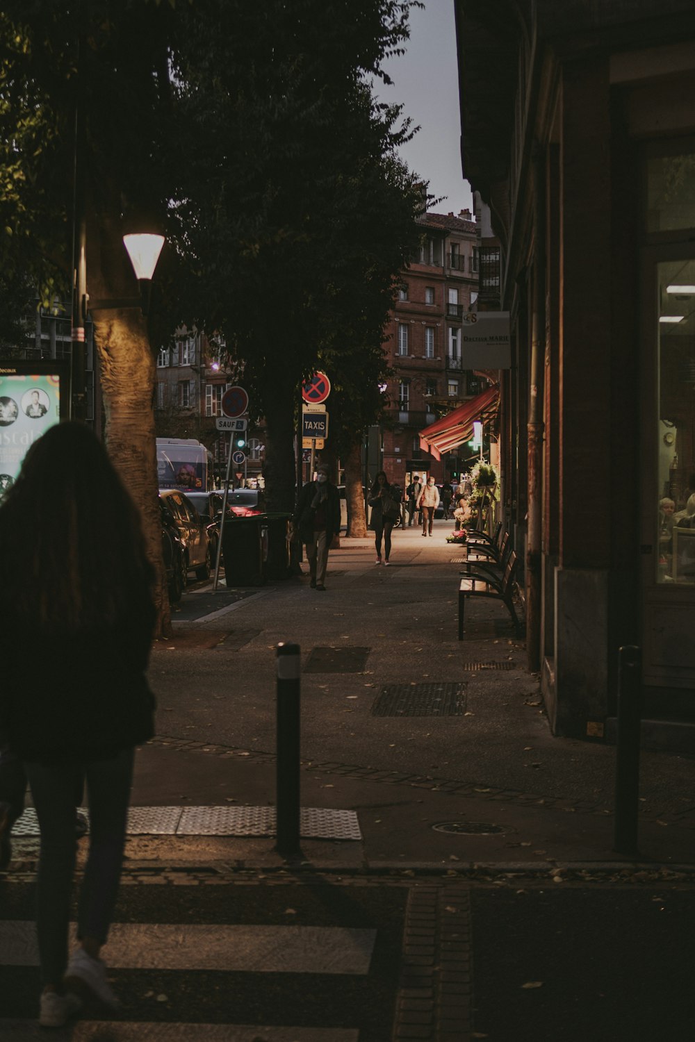 a woman walking down a street at night