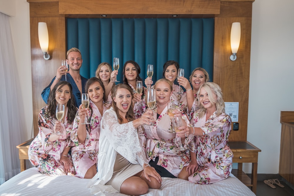 a group of women sitting on top of a bed