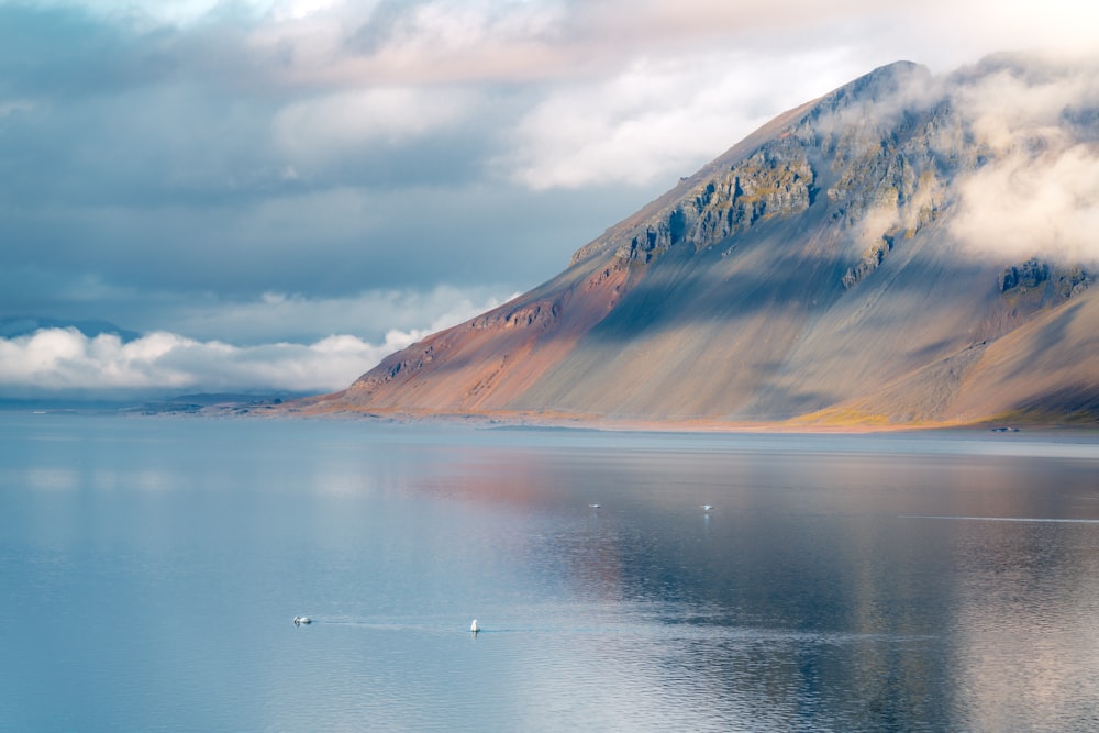 a large body of water with a mountain in the background