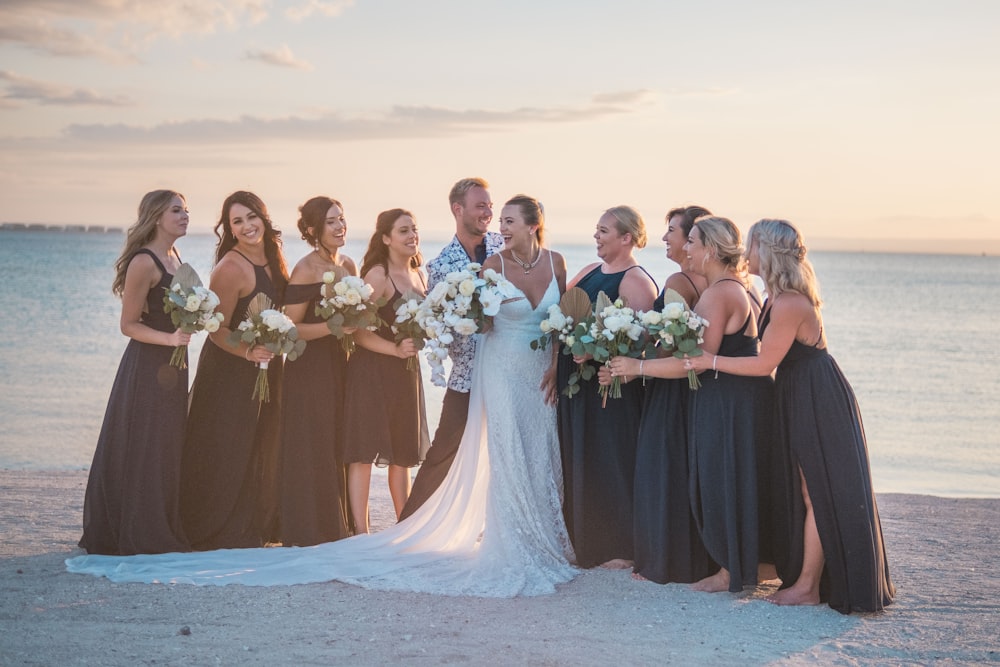 a group of women standing next to each other on a beach