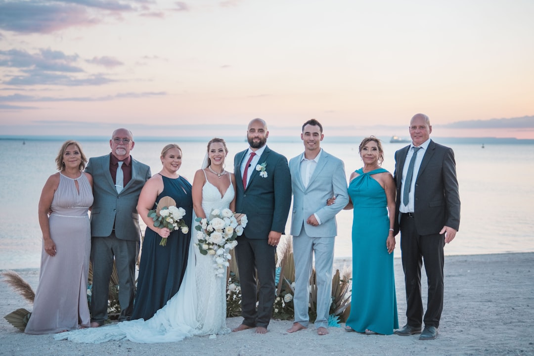 a group of people standing next to each other on a beach,