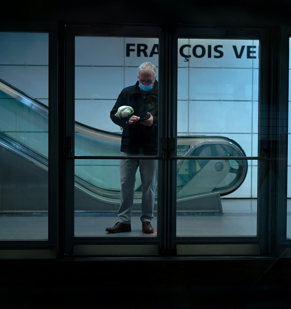 a man standing in front of a window holding a ball