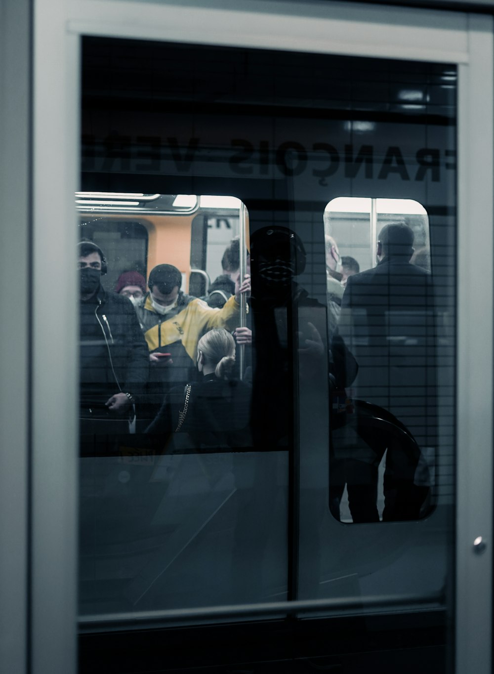 a group of people standing on a subway train