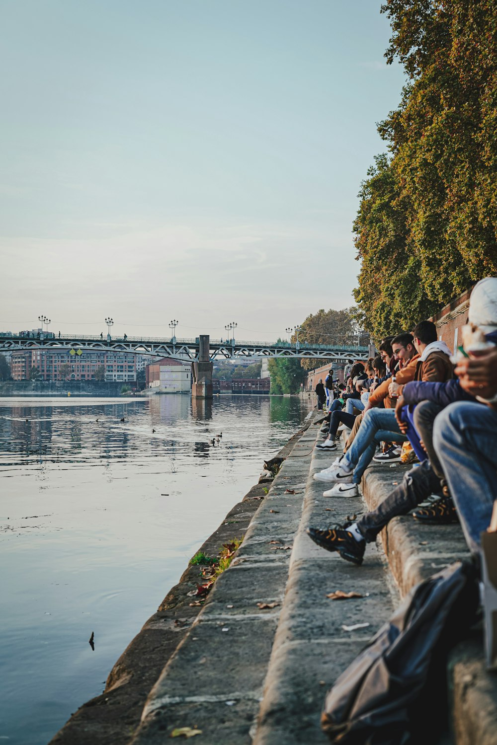 a group of people sitting next to a body of water