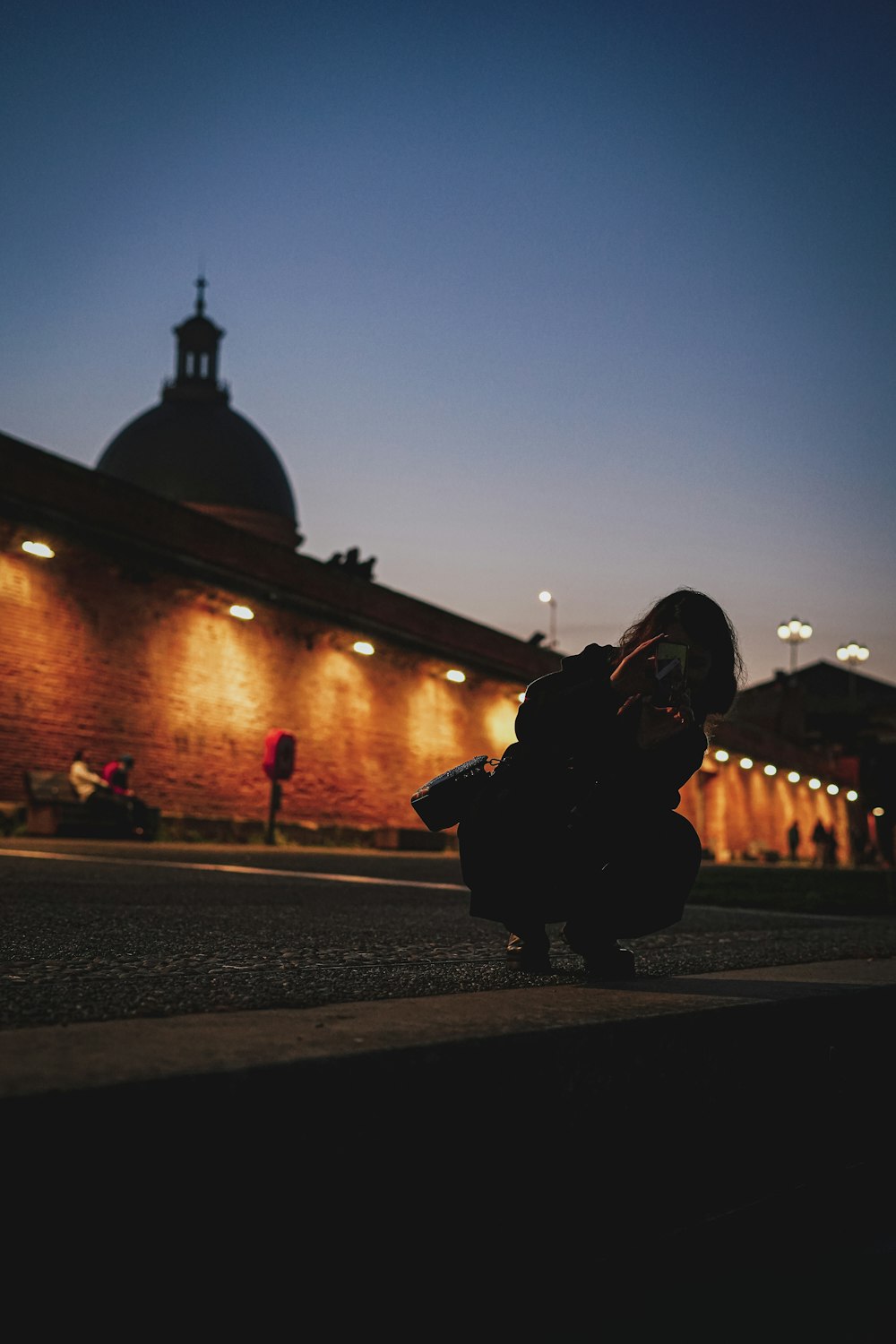 a person kneeling on the ground in front of a building