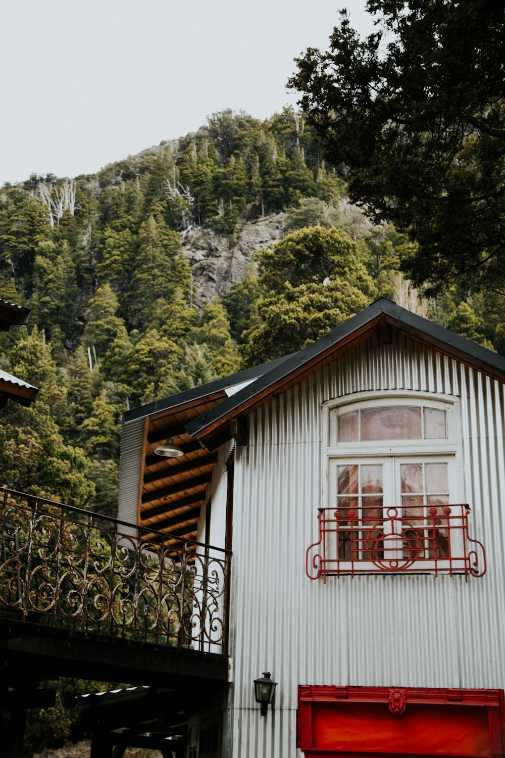 a white building with a red door and balcony