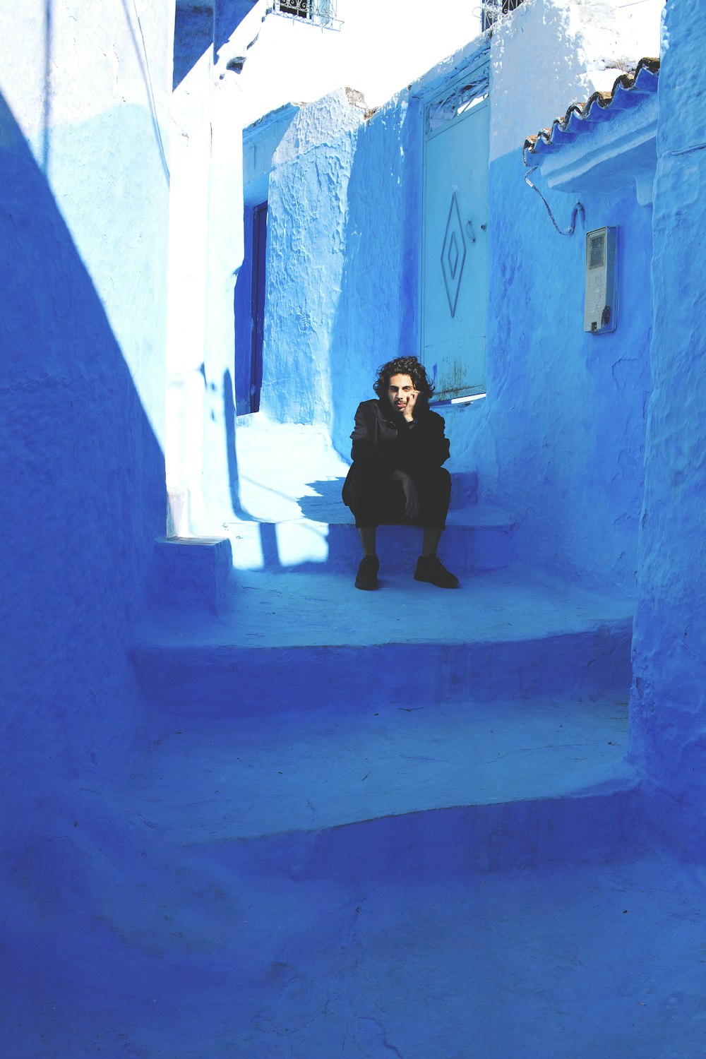 a woman sitting on a set of blue steps